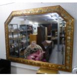 A LARGE ORNATE GILT FRAMED OBLONG BEVELLED EDGE WALL MIRROR, HAVING CANTED CORNERS TO THE TOP