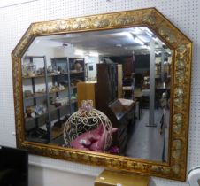 A LARGE ORNATE GILT FRAMED OBLONG BEVELLED EDGE WALL MIRROR, HAVING CANTED CORNERS TO THE TOP