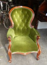 A VICTORIAN BALLOON BACK GENTLEMAN'S ARMCHAIR, COVERED IN GREEN VELOUR, WITH BUTTON BACK DECORATION
