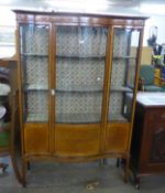 AN EDWARD VII MAHOGANY SERPENTINE DISPLAY CABINET, ON SQUARE TAPERING LEGS, 175cm HIGH