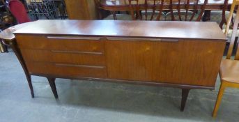 A SCANDINAVIAN TEAK LONG LOW SIDEBOARD, HAVING A DOUBLE SLIDING DOOR AND THREE LONG DRAWERS