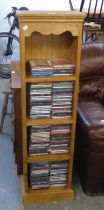 A PINE NARROW OPEN BOOKCASE AND A SELECTION OF CD'S