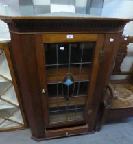 AN EDWARDIAN WALL-HUNG CORNER CABINET WITH LEADED GLASS DOOR AND UNDER DRAWER