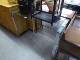 A MODERN GLASS TOP SIDE TABLE, RAISED ON CHROME SUPPORTS. TOGETHER WITH A LIGHT OAK TV CABINET (2)
