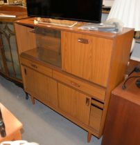 A 'SCHREIBER' TEAK WALL UNIT, HAVING TWO GLASS SLIDING DOORS AND A DROP-DOWN SECTION, ABOVE TWO