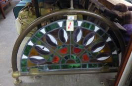 A STAINED GLASS BAR PANEL, SET INTO BRASS FRAMEWORK (DAMAGE TO THE STAINED GLASS)  AND A HEAVY