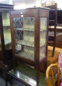 A CARVED MAHOGANY DISPLAY CABINET, WITH IMITATION ‘LEAD LIGHT’ GLAZED DOOR, ON STRAIGHT LEGS