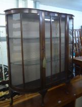 A MID-CENTURY WALNUT WOOD BOW FRONTED DISPLAY CABINET