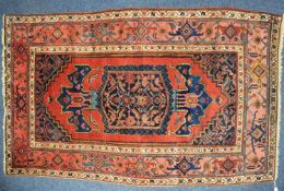 LARGE EASTERN RUG, with red plain field mostly filled by the large rectangular centre midnight