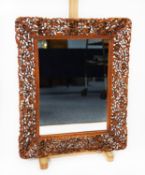 MODERN ANGLO PERSIAN CARVED AND PIERCED BLONDE WOOD WALL MIRROR, the oblong plate within a chamfered