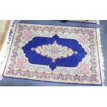 PAIR OF KIRMAN, PERSIAN RUGS each with a narrow lozenge shaped centre medallion, on a dark blue
