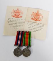 TWO WORLD WAR II MEDALS WITH RIBBONS, sewn onto a bar brooch, 1939 - 1945 The Defence Medal and
