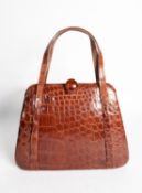 LADY'S VINTAGE CROCODILE HANDBAG, with clip-over clasp, set with a large circular cabochon amber,