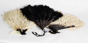 TWO OSTRICH FEATHER FANS, one black, one white, both with imitation tortoiseshell sticks; a WHITE