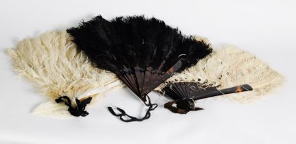 TWO OSTRICH FEATHER FANS, one black, one white, both with imitation tortoiseshell sticks; a WHITE