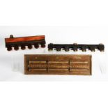 R. HOUGH'S PATENT FIVE-SLOT CAST IRON MURAL CUE RACK. 12in (30.5cm) wide, mounted on a wooden panel;