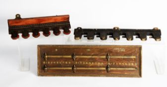 R. HOUGH'S PATENT FIVE-SLOT CAST IRON MURAL CUE RACK. 12in (30.5cm) wide, mounted on a wooden panel;
