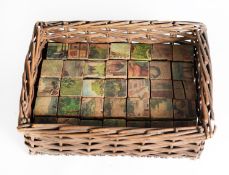 THIRTY FIVE EDWARDIAN SIX-SIDED WOODEN LITHOGRAPHED JIGSAW BLOCKS, contained in a covered wicker box