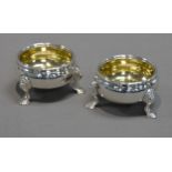 PAIR OF EARLY VICTORIAN SILVER SALT CELLARS with gilded interiors, each on three stepped pad feet,