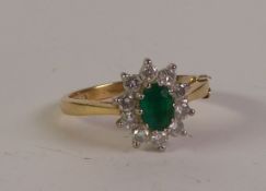 18CT GOLD EMERALD AND DIAMOND CLUSTER RING, an oval-cut emerald within a border of round brilliant-