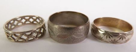 A SILVER BROAD BAND RING, with leaf engraving on a textured background, A SILVER BROAD BAND RING,