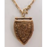 GOLD BACK AND FRONT FANCY SHIELD-SHAPED LOCKET PENDANT, with foliate engraved decoration, on a 9CT