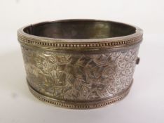 VICTORIAN BROAD HINGE OPENING BANGLE, the front engraved with ivy leaf decoration, unmarked, 3.1cm