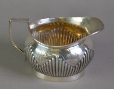 LATE VICTORIAN SILVER MILK JUG BY MAPPIN & WEBB, of oval part fluted form with angular scroll handle