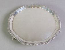 GEORGE V PLAIN SILVER WAITER, of typical form with gadrooned wavy border and claw and ball feet,