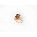 GOLD COLOURED METAL DRESS RING, set with an oval smoky quartz stone, the shank of four strand wire