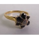 18CT GOLD SAPPHIRE AND DIAMOND CLUSTER RING, a round brilliant-cut diamond within a sapphire border,