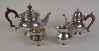 MATCHED FOUR PIECE GEORGIAN STYLE PLAIN SILVER TEASET, of footed bellied form with brown scroll