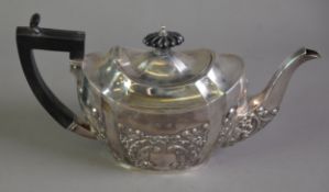 LATE VICTORIAN EMBOSSED SILVER BACHELOR’S TEAPOT BY W M HAYES, of shaped oval form with black