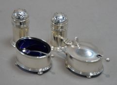 INTER-WAR YEARS SILVER FOUR PIECE CONDIMENT SET comprising a pair of pepperettes, salt cellar and