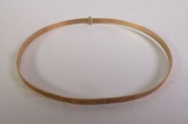 A NARROW 9CT GOLD BANGLE, with engraved decoration, slide extending action, 2.9gms