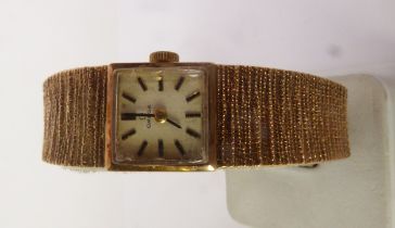 LADY’S 9CT GOLD OMEGA WRISTWATCH, square silvered dial with batons, to an integral textured bracelet