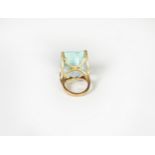 GOLD COLOURED METAL DRESS RING, set with a large oblong pale blue stone in a four claw setting, ring