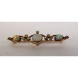 AN EARLY 20TH CENTURY OPAL AND DIAMOD BROOCH, three graduated oval opals spaced by groups of old-cut