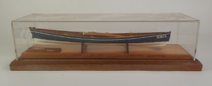 PAINTED WOOD MODEL OF THE ST. MARY’S ROWING GIG, ‘SERICA’, with oars, 17” (43.2cm) long, on wooden