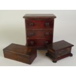 EARLY TWENTIETH CENTURY EBONY MONEY BOX, of moulded oblong form with bun type feet and slot to the