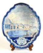 19th CENTURY DUTCH DELFT, SHAPED OVAL WALL PLAQUE, painted with a canal scene, moulded border,