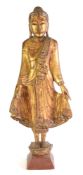 CARVED AND GILT WOOD SOUTH EAST ASIAN BUDDHISTIC FIGURE, the headdress and costume decorated with