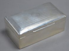 GEORGE V ENGINE TURNED SILVER CLAD TABLE CIGARETTE BOX, of typical form with hardwood lined