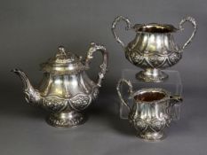 VICTORIAN EMBOSSED SILVER THREE PIECE PEDESTAL TEASET, of bellied form with acanthus capped high