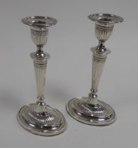 GEORGE V PAIR OF WEIGHTED SILVER COLUMN CANDLESTICKS, each of part fluted, oval form with beaded