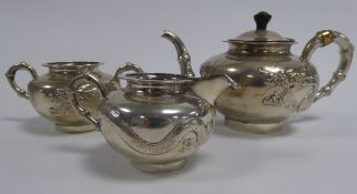 THREE PIECE CHINESE EMBOSSED SILVER COLOURED METAL TEA SET, of compressed, footed form with bamboo