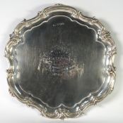 SILVER CIRCULAR SALVER, with shaped and moulded and rococo embossed border, on three rococo tab