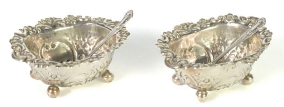 PAIR OF VICTORIAN SILVER OVAL SALT RECEIVERS, repousse with flowers and rococo scrolls on the