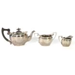 GEORGE V SILVER THREE PIECE TEASET BY CHARLES BOYTTON & SON, of oval part fluted form with angular
