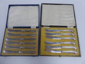 TWO CASED SETS OF SIX AFTERNOON TEA KNIVES WITH FILLED SILVER HANLDES, one set with pistol grip